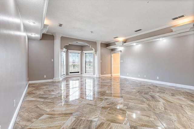 unfurnished room with crown molding, a textured ceiling, and ornate columns