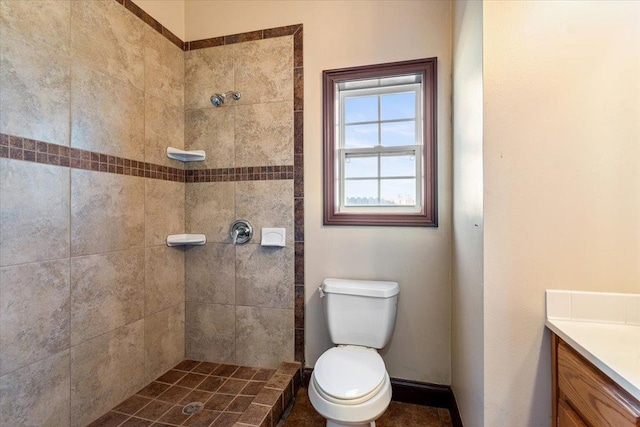 bathroom featuring vanity, toilet, and a tile shower