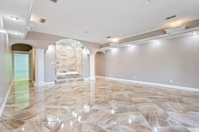 unfurnished living room with a textured ceiling and ornate columns