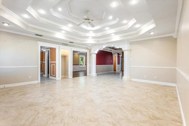 spare room with crown molding, a tray ceiling, decorative columns, and ceiling fan