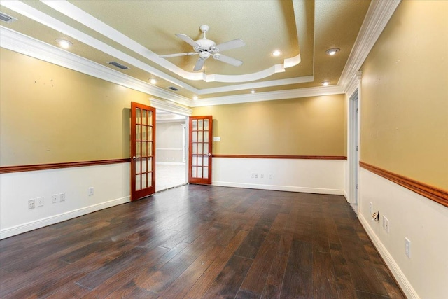 unfurnished room with ornamental molding, ceiling fan, a raised ceiling, dark wood-type flooring, and french doors