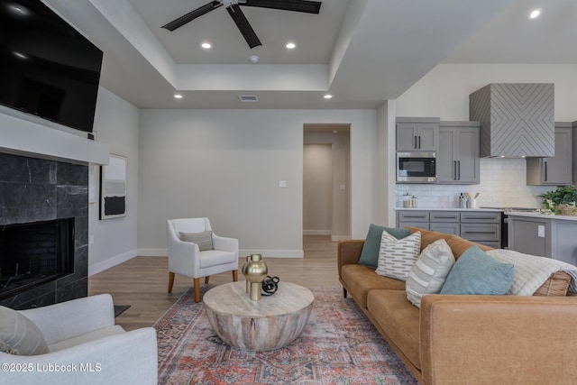 5713 119th St, Lubbock, TX 79424 - living area featuring a ceiling fan, a fireplace, light wood-style floors, baseboards, and recessed lighting