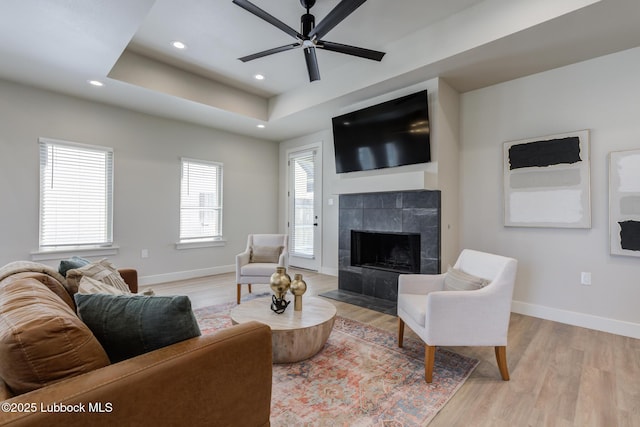 5713 119th St, Lubbock, TX 79424 - living room featuring baseboards, light wood-style flooring, recessed lighting, a fireplace, and a tray ceiling