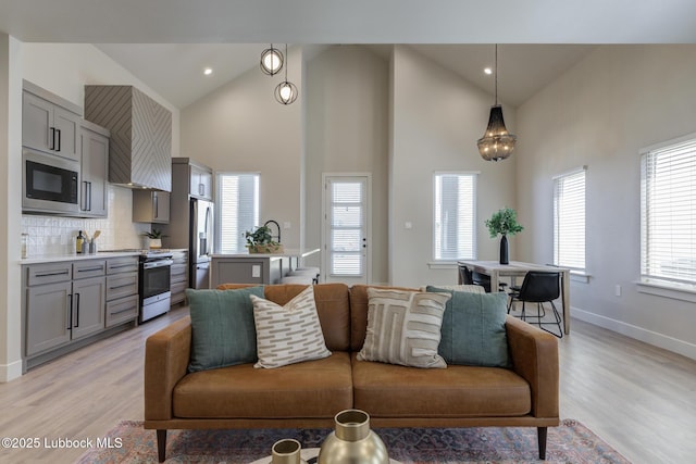 5713 119th St, Lubbock, TX 79424 - living room with light wood-type flooring, high vaulted ceiling, baseboards, and recessed lighting