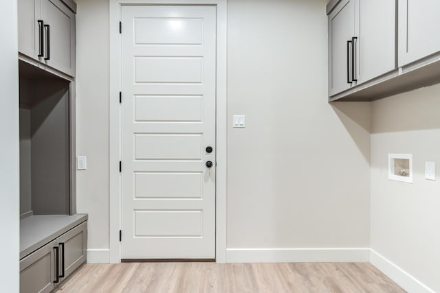 5713 119th St, Lubbock, TX 79424 - washroom with hookup for a washing machine, cabinet space, light wood-style flooring, and baseboards