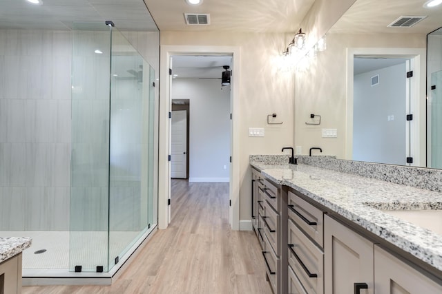5713 119th St, Lubbock, TX 79424 - full bath featuring double vanity, a stall shower, wood finished floors, baseboards, and recessed lighting