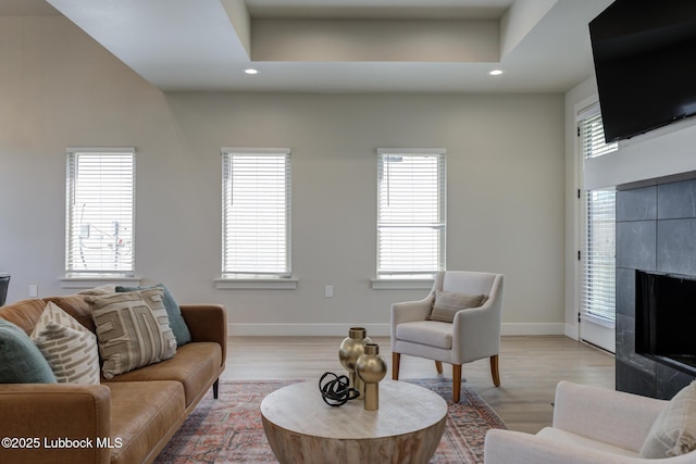 5713 119th St, Lubbock, TX 79424 - living area with recessed lighting, baseboards, a tiled fireplace, and light wood-style flooring