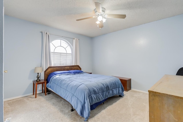 carpeted bedroom with ceiling fan and a textured ceiling