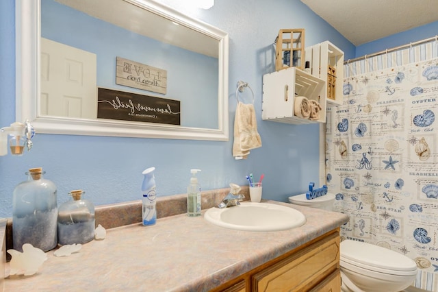 bathroom featuring a shower with curtain, vanity, toilet, and a textured ceiling