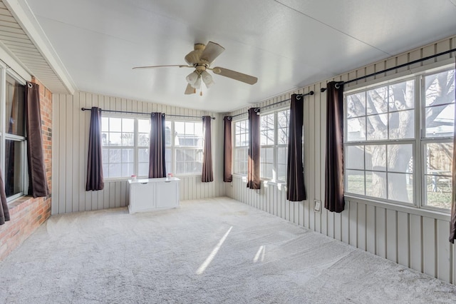 unfurnished sunroom with ceiling fan