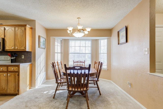 carpeted dining room with a textured ceiling and an inviting chandelier