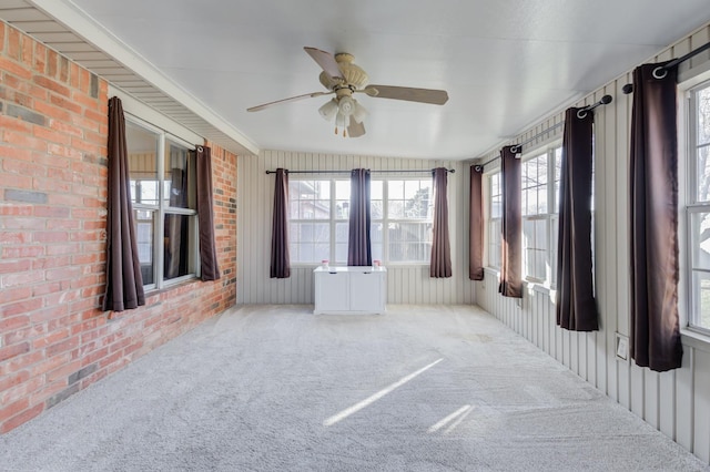 unfurnished sunroom with ceiling fan and a healthy amount of sunlight