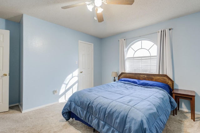 carpeted bedroom with ceiling fan and a textured ceiling