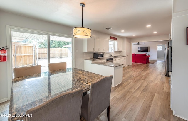3410 53rd St, Lubbock, TX 79413 - kitchen with stainless steel appliances, white cabinetry, light wood-style flooring, recessed lighting, and tasteful backsplash