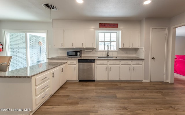 3410 53rd St, Lubbock, TX 79413 - kitchen featuring stainless steel appliances, white cabinetry, decorative backsplash, wood finished floors, and recessed lighting