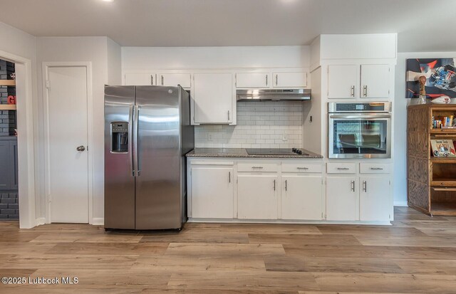 3410 53rd St, Lubbock, TX 79413 - kitchen with appliances with stainless steel finishes, under cabinet range hood, white cabinets, tasteful backsplash, and light wood-style floors