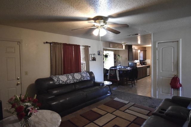 living room featuring ceiling fan, a textured ceiling, and light tile patterned floors