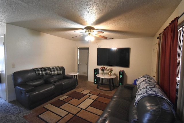 carpeted living room featuring ceiling fan and a textured ceiling