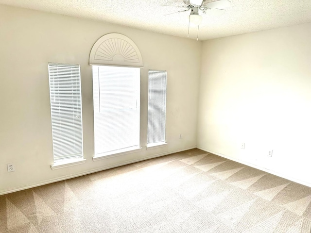 carpeted empty room with ceiling fan and a textured ceiling