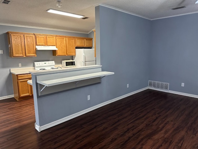 kitchen featuring a breakfast bar, ornamental molding, white appliances, dark wood-type flooring, and a textured ceiling