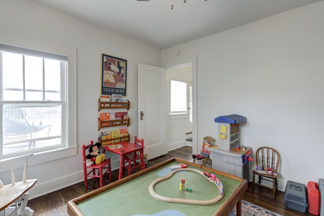 playroom featuring baseboards, a ceiling fan, plenty of natural light, and wood finished floors