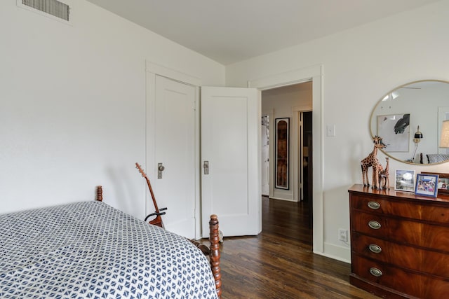 bedroom featuring visible vents, baseboards, and dark wood-style floors