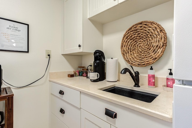 kitchen featuring a sink, light countertops, and white cabinetry