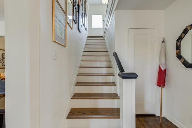 stairs featuring wood finished floors and baseboards