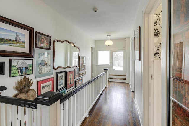 corridor featuring an upstairs landing and dark wood finished floors