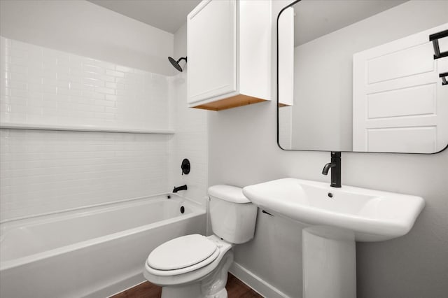 bathroom with hardwood / wood-style flooring, tub / shower combination, and toilet