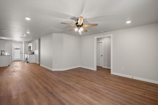 unfurnished living room featuring sink, dark hardwood / wood-style floors, and ceiling fan