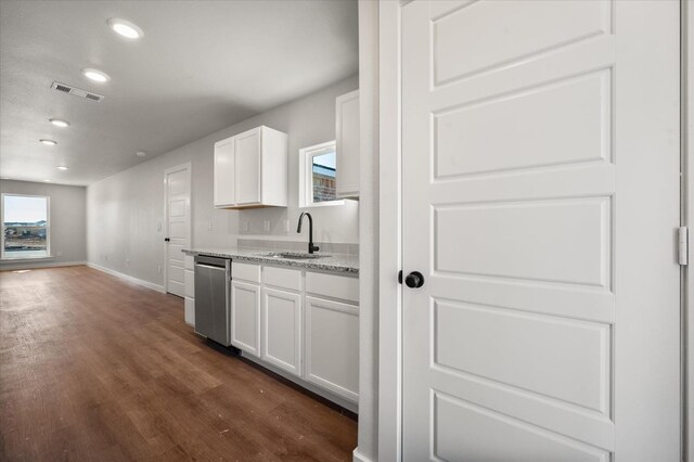 kitchen featuring sink, light stone counters, dark hardwood / wood-style floors, dishwasher, and white cabinets