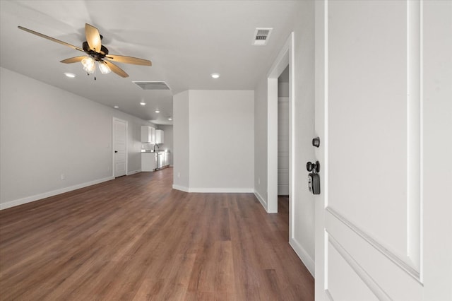 unfurnished living room featuring ceiling fan and dark hardwood / wood-style flooring