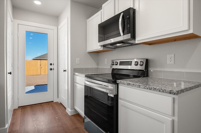 kitchen featuring dark hardwood / wood-style flooring, electric range, light stone countertops, and white cabinets