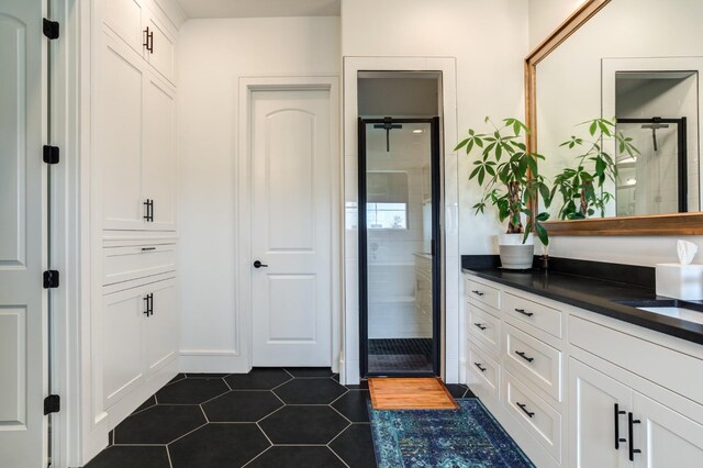 bathroom featuring tile patterned floors, an enclosed shower, and vanity