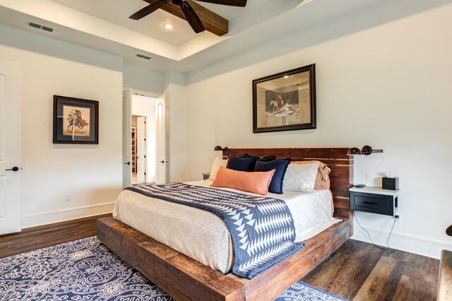 bedroom with beamed ceiling, ceiling fan, and dark hardwood / wood-style floors