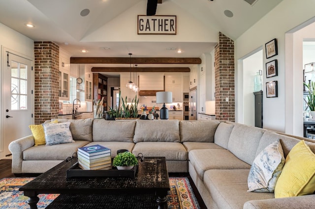 living room featuring lofted ceiling, sink, and hardwood / wood-style floors