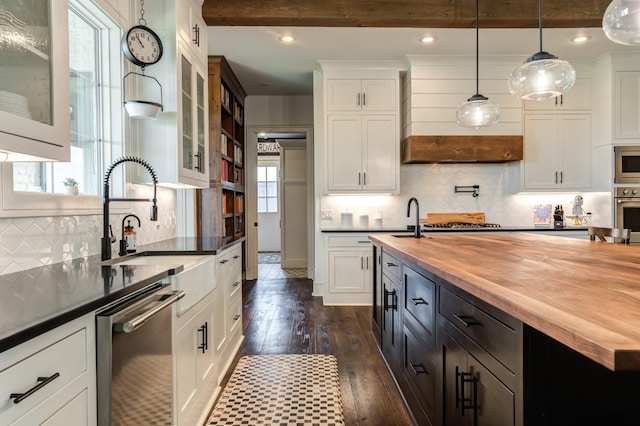 kitchen featuring pendant lighting, sink, dark wood-type flooring, stainless steel appliances, and wood counters