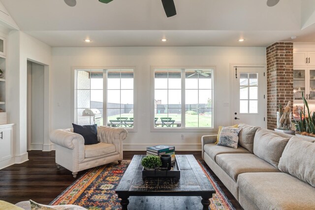 living room with dark wood-type flooring and ceiling fan