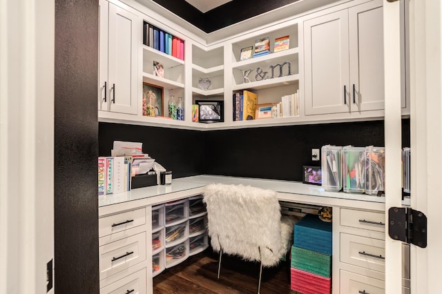 office with built in desk and dark hardwood / wood-style floors