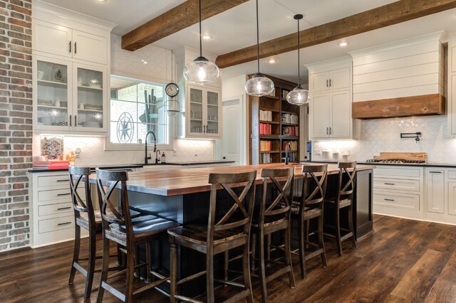 kitchen featuring white cabinetry, a center island, and dark wood-type flooring