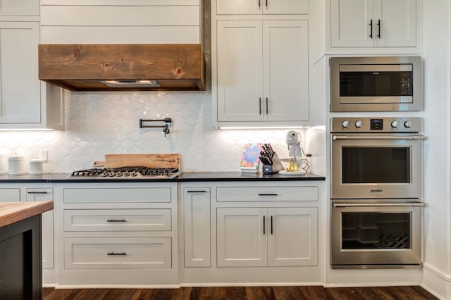 kitchen featuring stainless steel appliances, white cabinetry, and tasteful backsplash