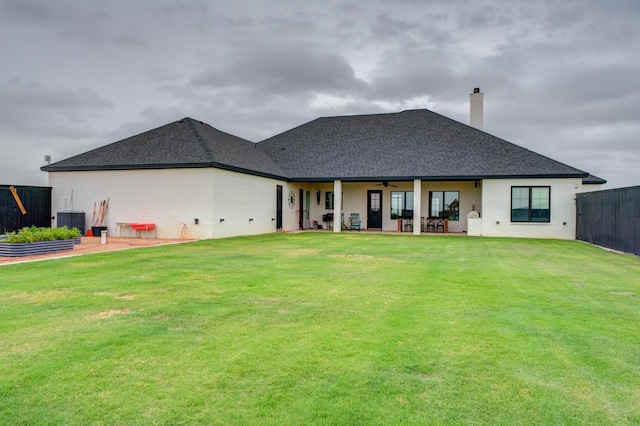 back of house with cooling unit, a patio, and a lawn