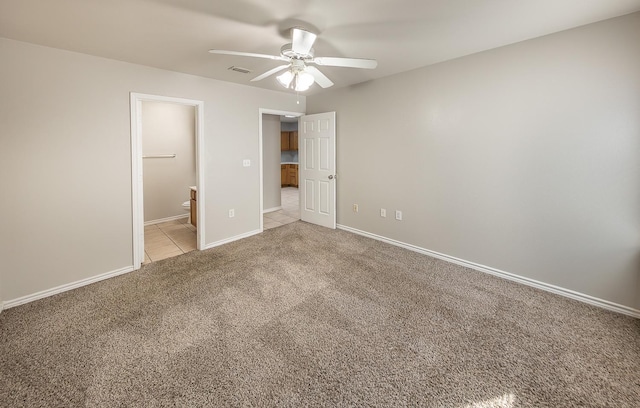 unfurnished bedroom with light carpet, ceiling fan, and ensuite bath