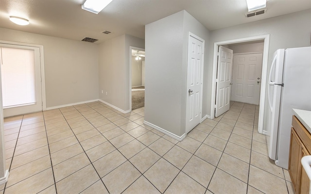 kitchen with light tile patterned floors, ceiling fan, and white refrigerator