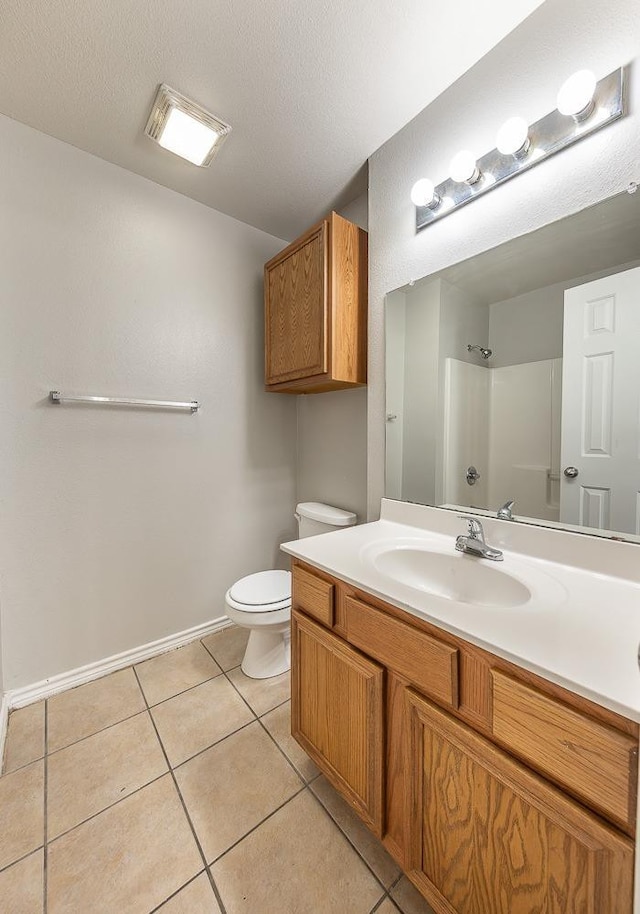 bathroom featuring toilet, vanity, tile patterned floors, and walk in shower