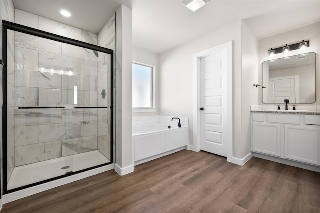 bathroom featuring wood-type flooring, independent shower and bath, and vanity