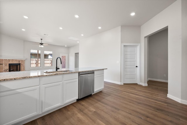 kitchen featuring sink, dishwasher, hardwood / wood-style floors, light stone countertops, and white cabinets