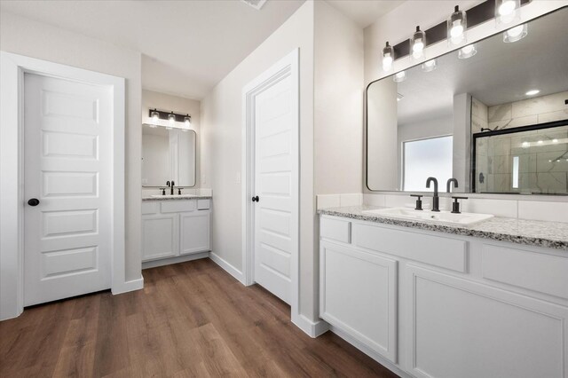 bathroom with hardwood / wood-style flooring, vanity, and a shower with shower door