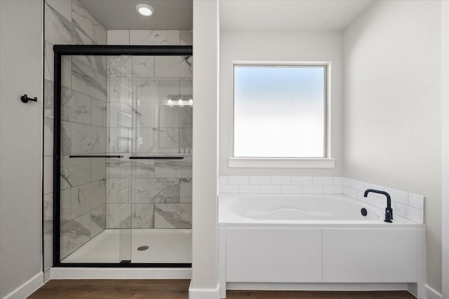 bathroom featuring a wealth of natural light, independent shower and bath, and wood-type flooring